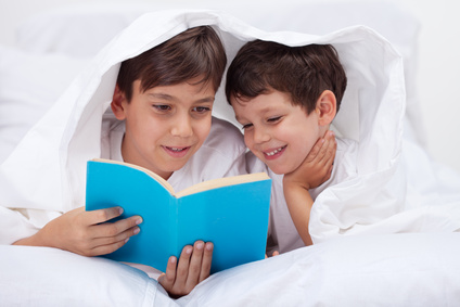 Kids reading under the blanket